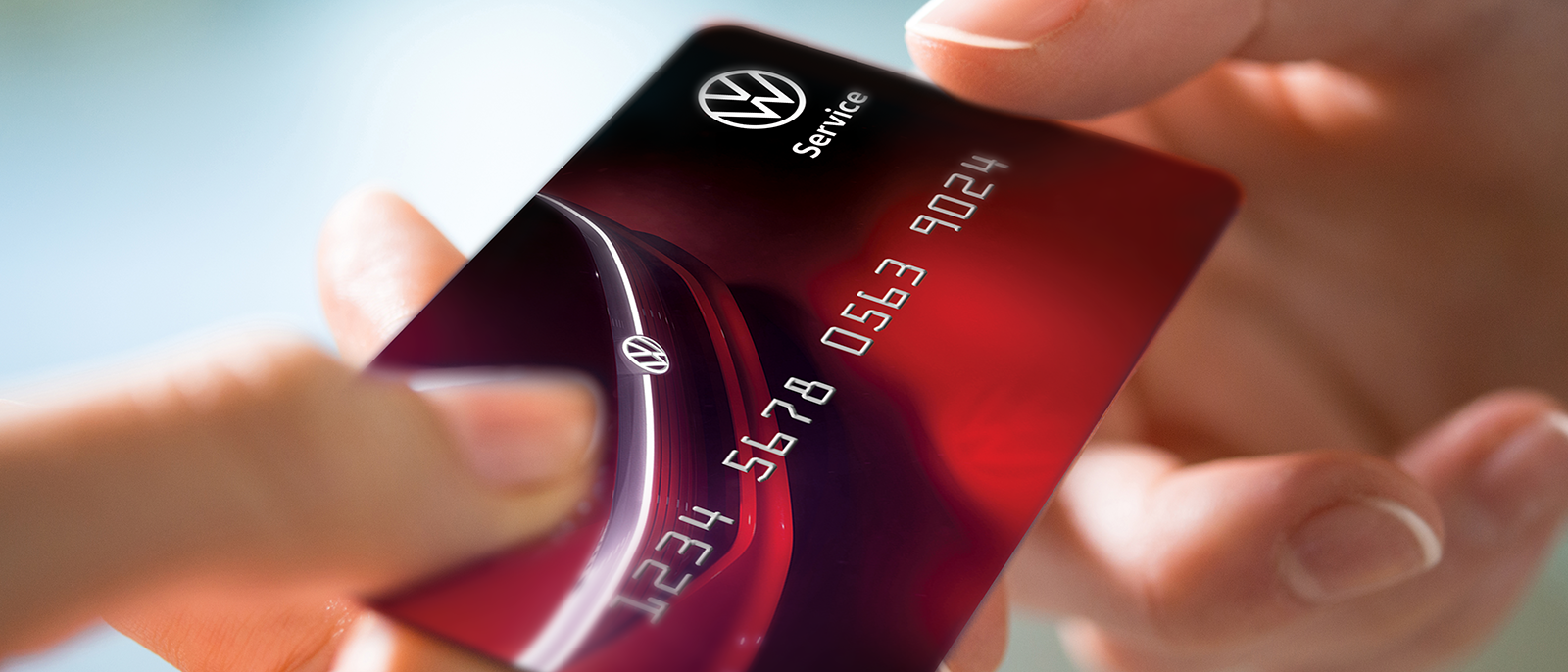 A person handing a Volkswagen service credit card