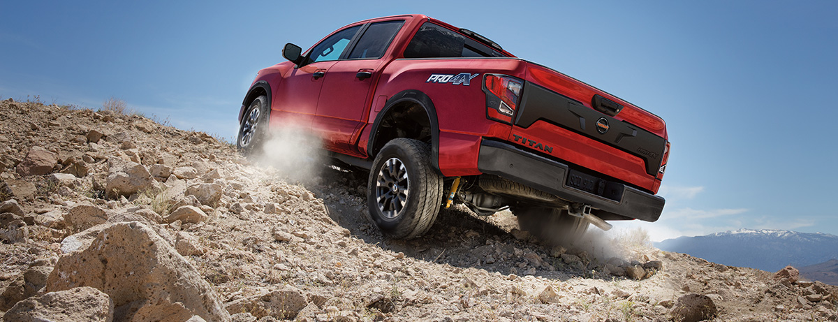 Red 2020 NIssan Titan driving up a rocky hill
