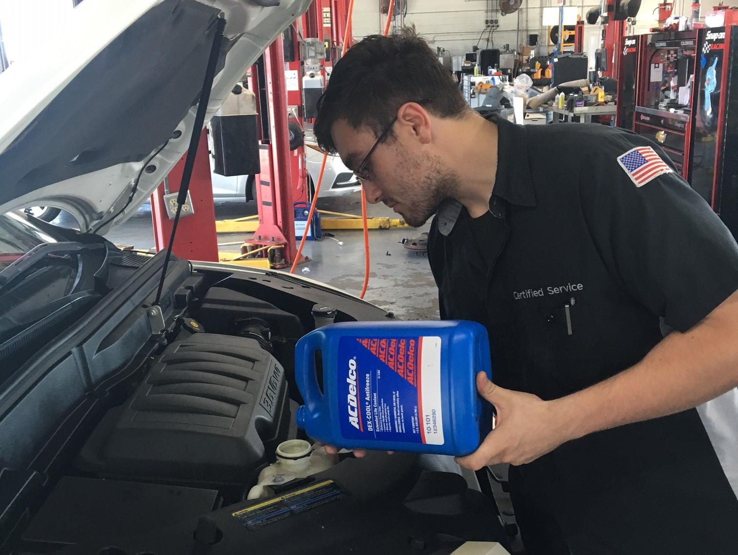 Service technician checking vehicle oil