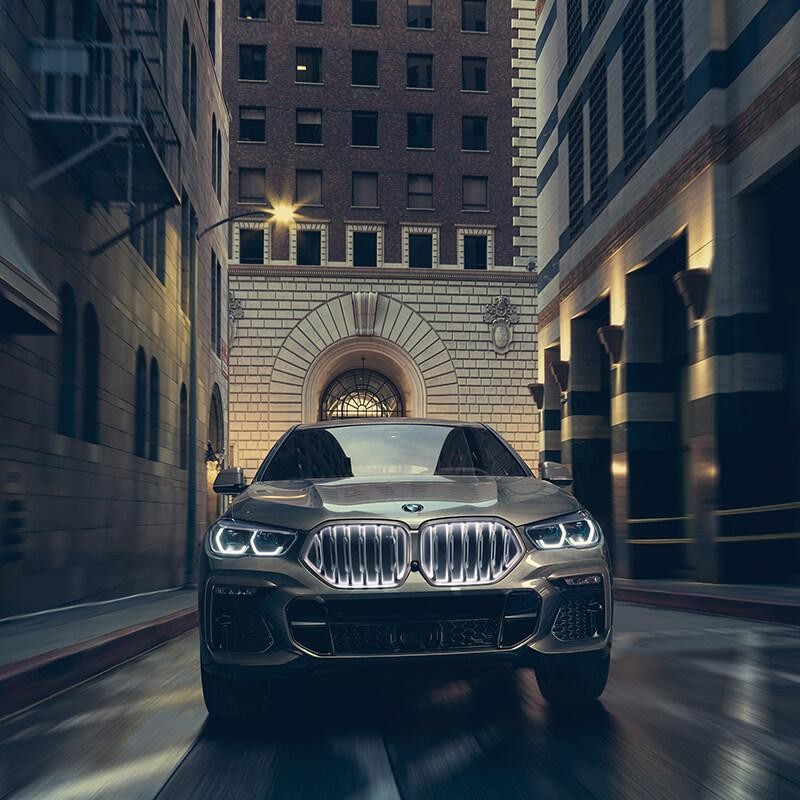 Front view of a BMW X6 driving in a city at night