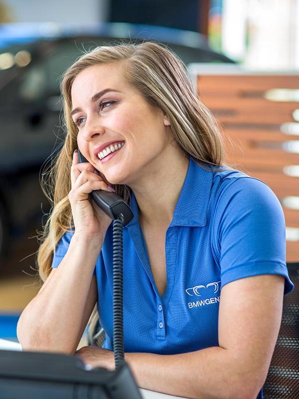 A young woman BMW representative talking on the phone.