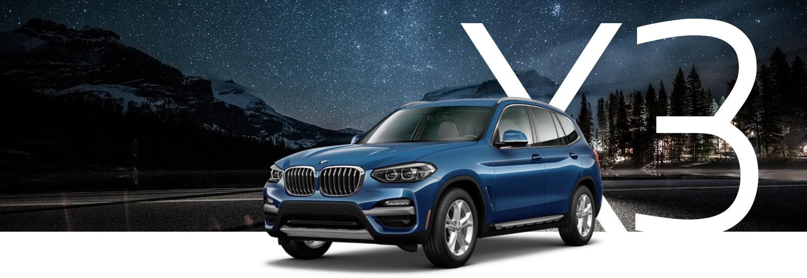 A blue BMW X3 parked under a starry sky.