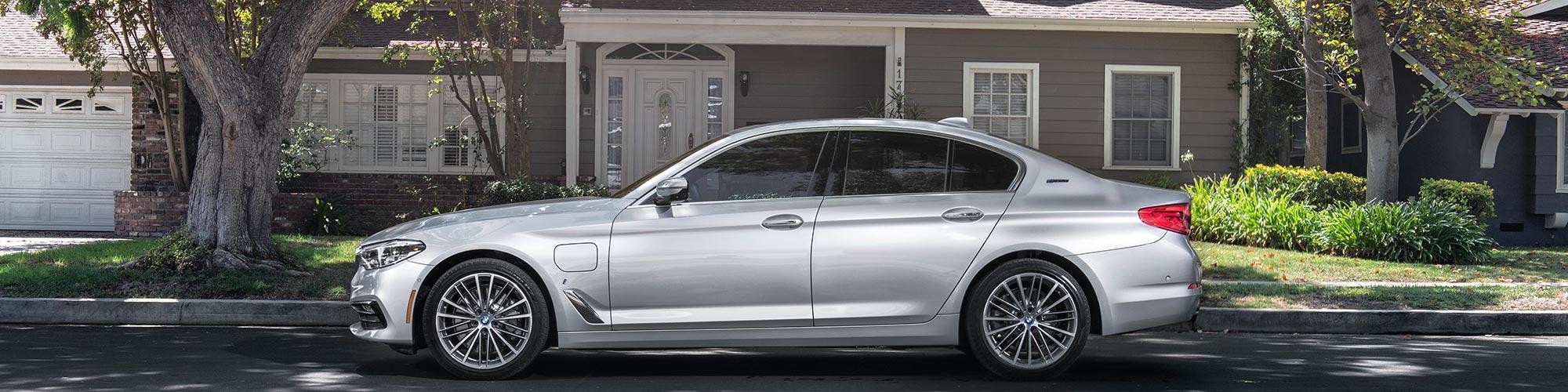 A silver BMW 5 Series parked on a suburban street.