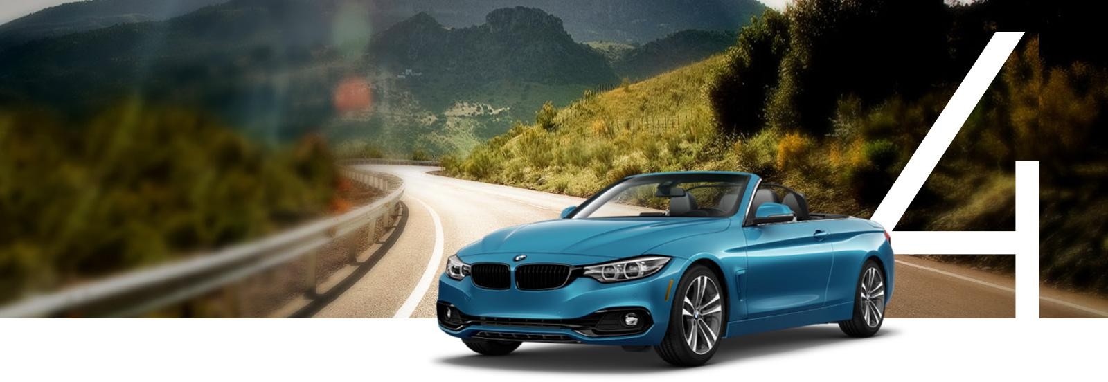 A teal blue BMW 4 Series on a windy country road.