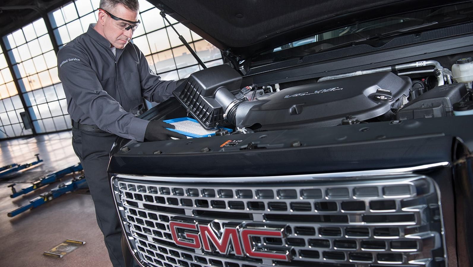 GMC certified service mechanic replacing a vehicle's air filter