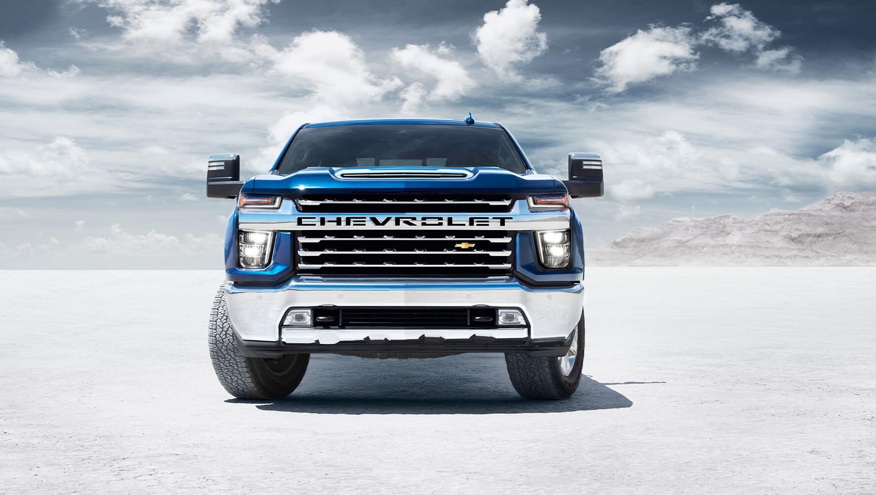 A blue Chevy Silverado HD parked in open space