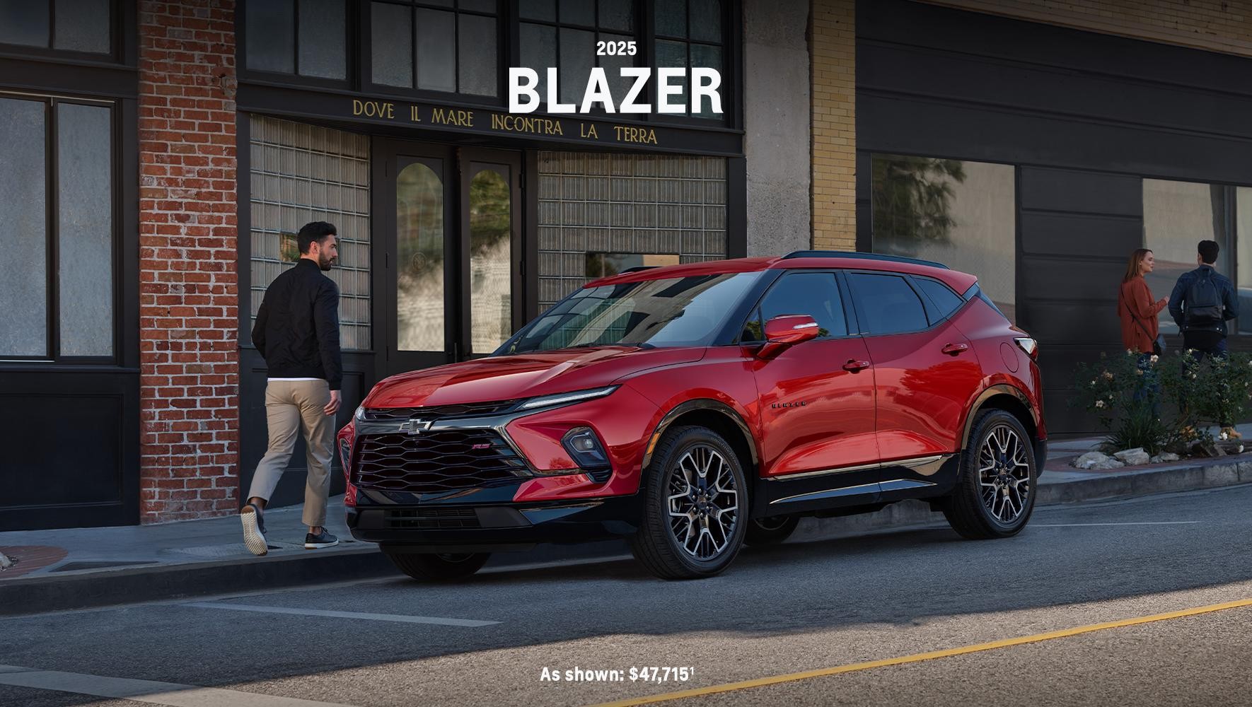 Red 2025 Blazer parked by a sidewalk in a city