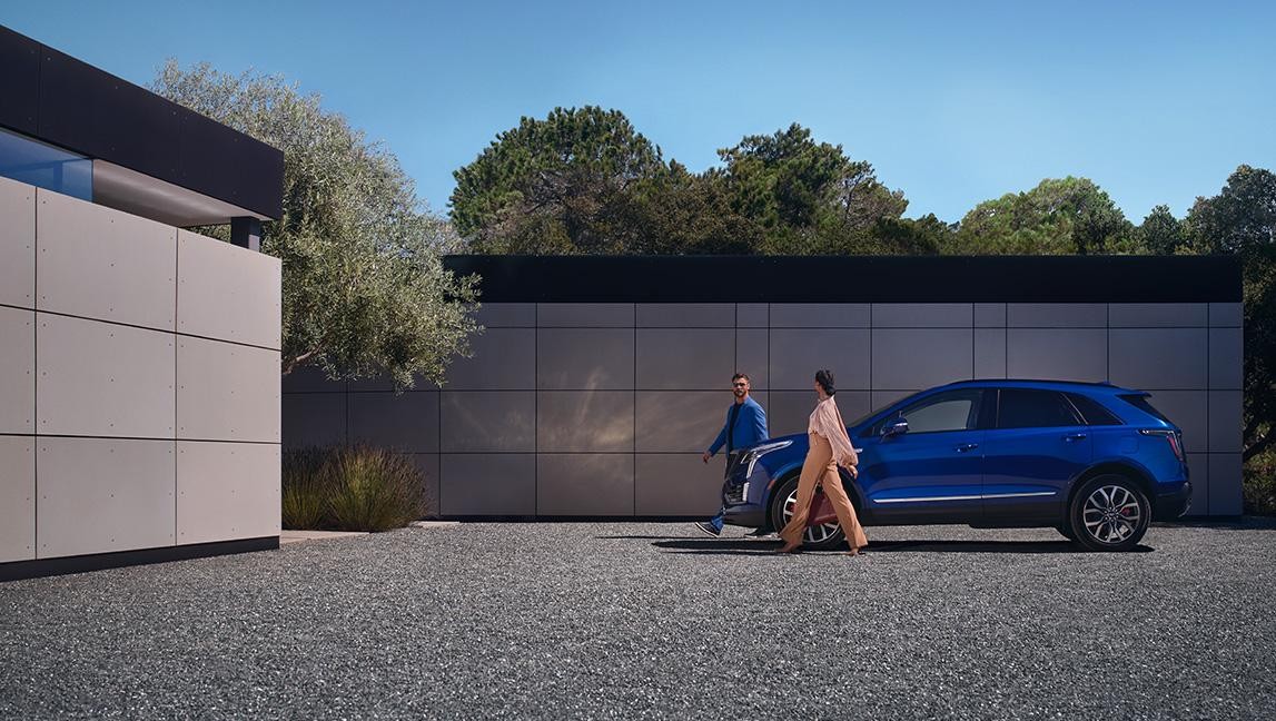 A Couple Walks Away From Their Parked 2024 Cadillac XT5 A Couple Walks Away From Their Parked 2024 Cadillac XT5