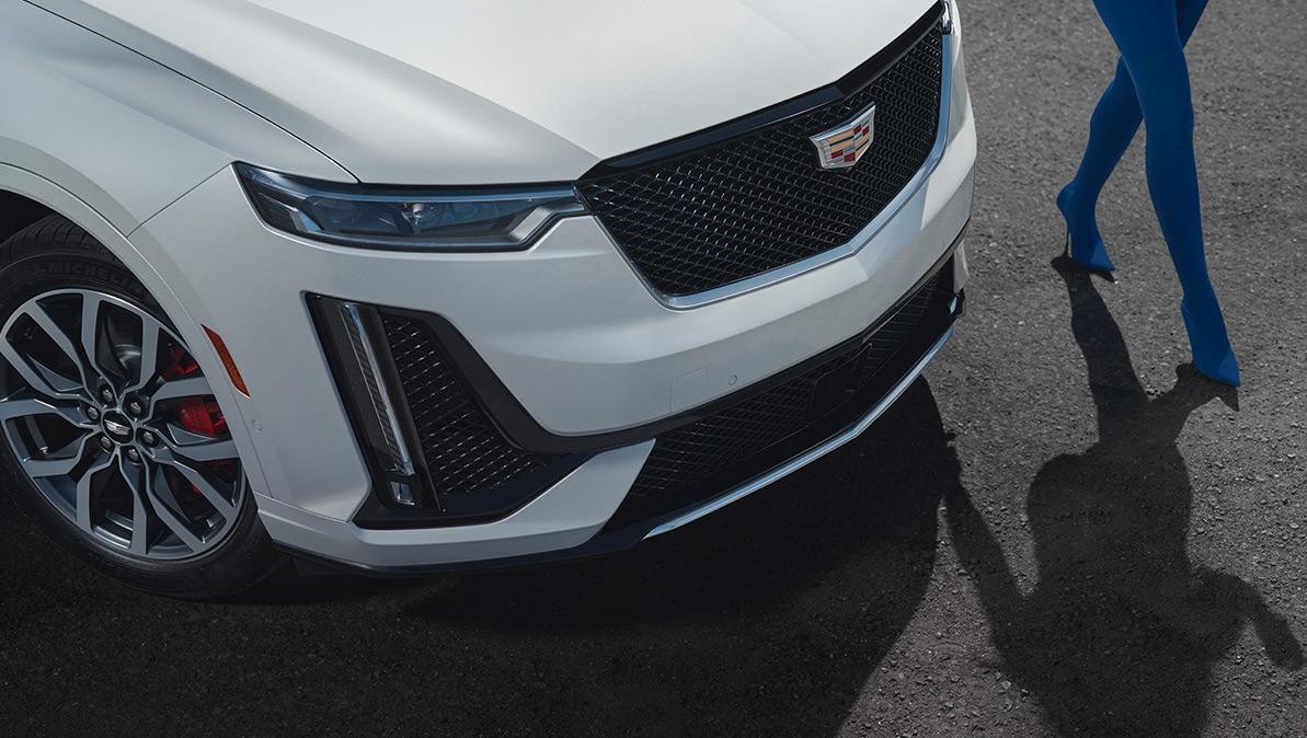 A Person Walks Along Side of a Parked Cadillac XT6. A Person Walks Along Side of a Parked Cadillac XT6.