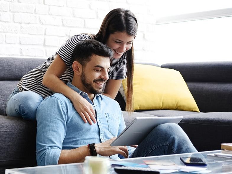 Una pareja busca un auto nuevo en línea en casa.