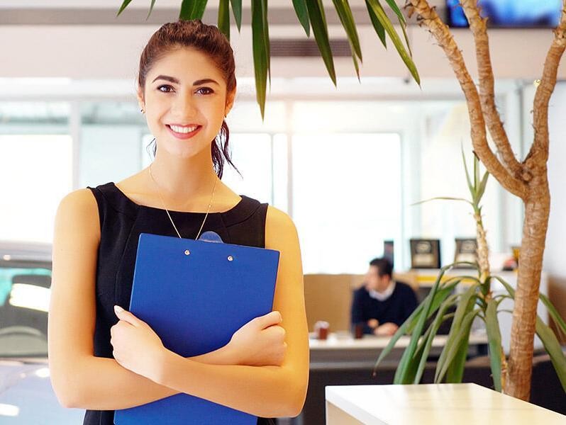 Recepcionista sonriente sosteniendo un portapapeles