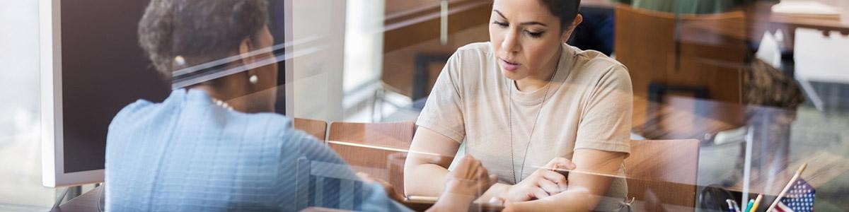Dos mujeres revisando el papeleo financiero.