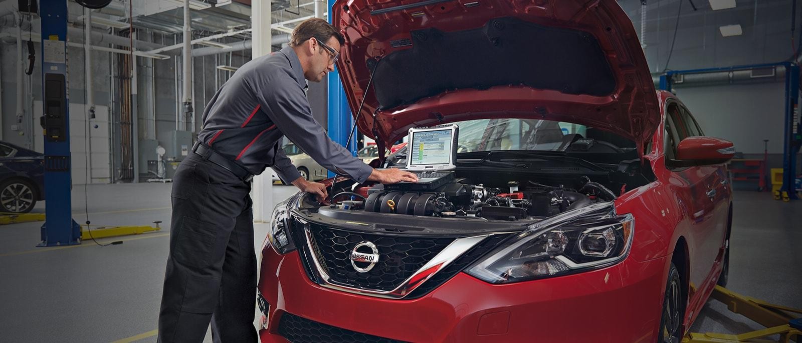 Nissan service mechanic running diagnostics on a vehicle