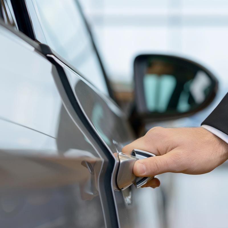 A man's hand on a car door handle