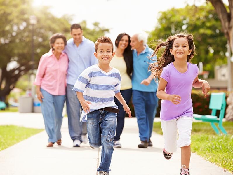 Happy family with kids walking through a park