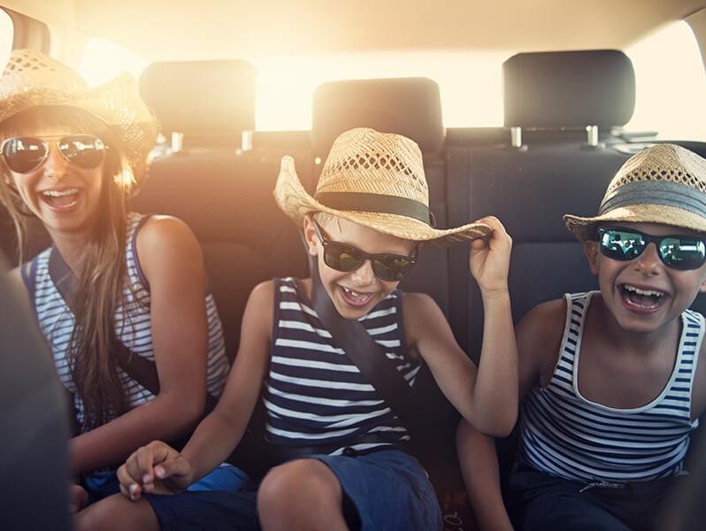 Smiling children in the backseat of a car