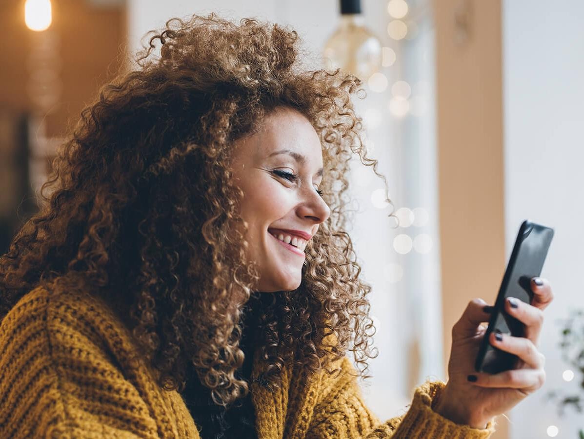 Smiling woman looking at her cell phone