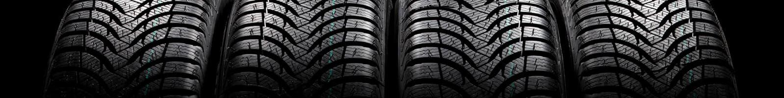 A row of vehicle tires on a dark background