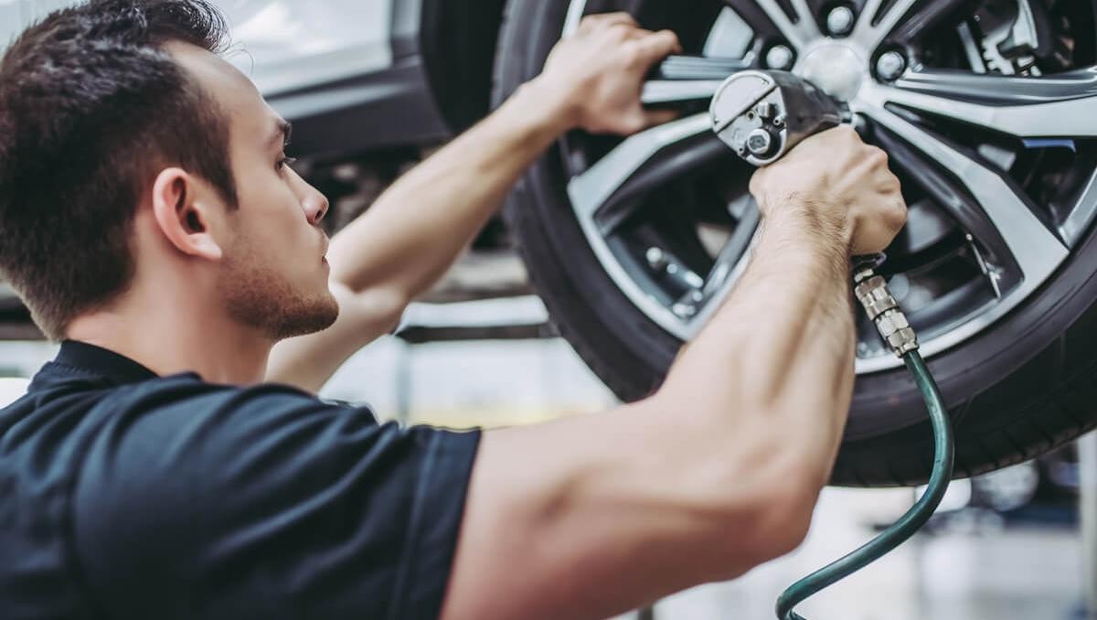 Mechanic in uniform is working in auto service