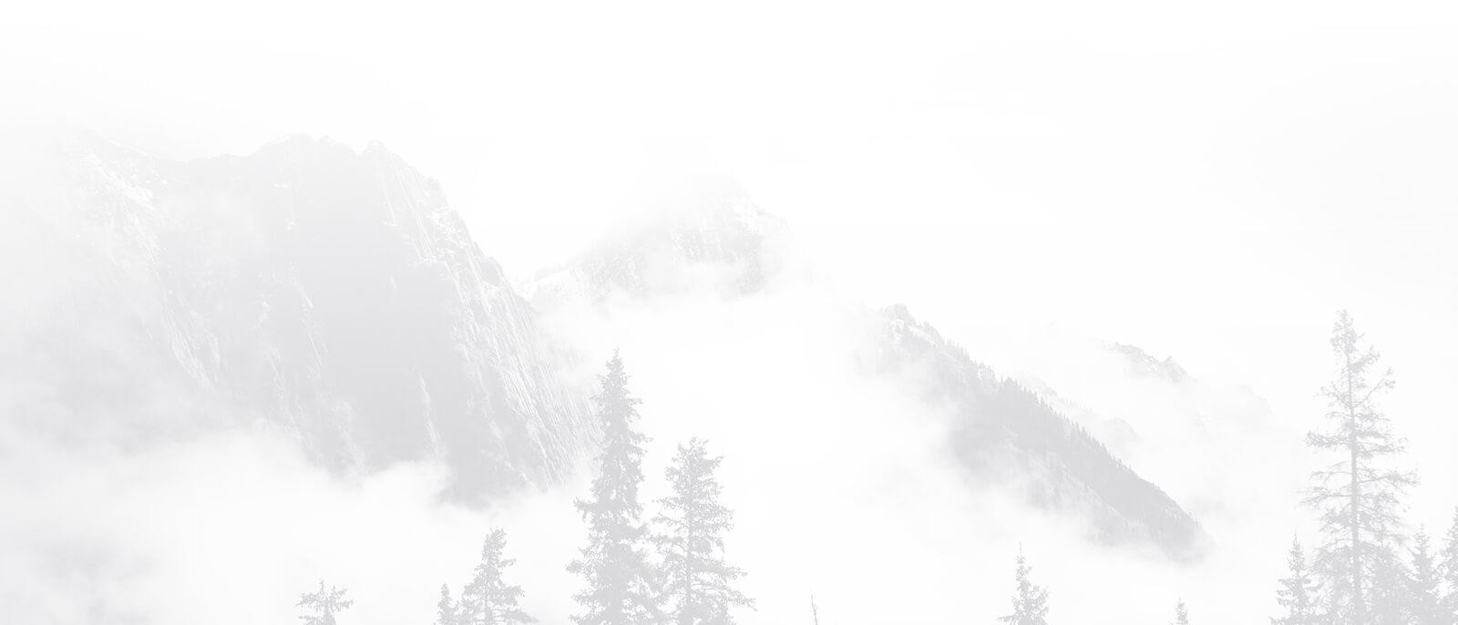 Landscape with rocky mountains, trees and foggy clouds