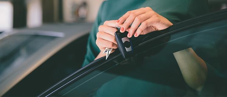 Woman holding keys to a new car.