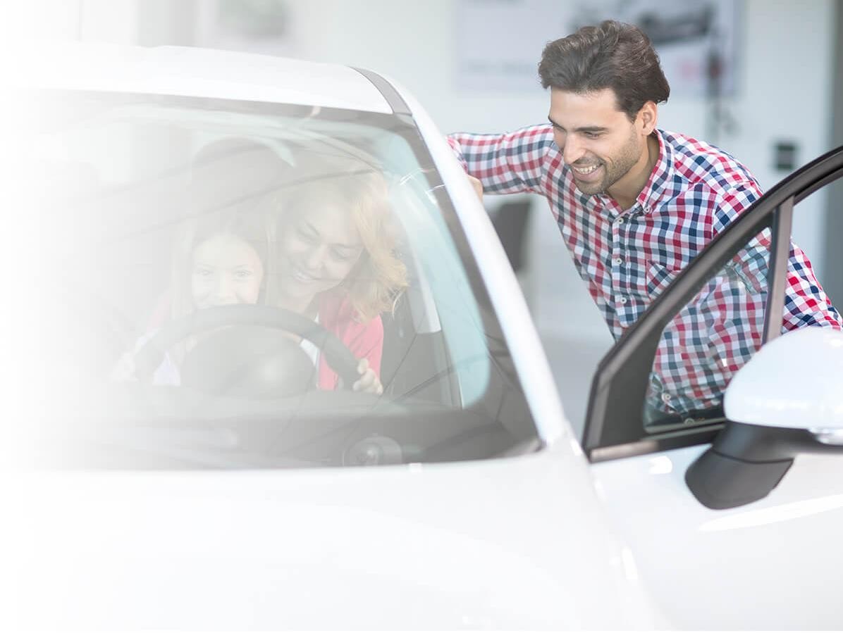 Familia joven comprando un vehículo nuevo