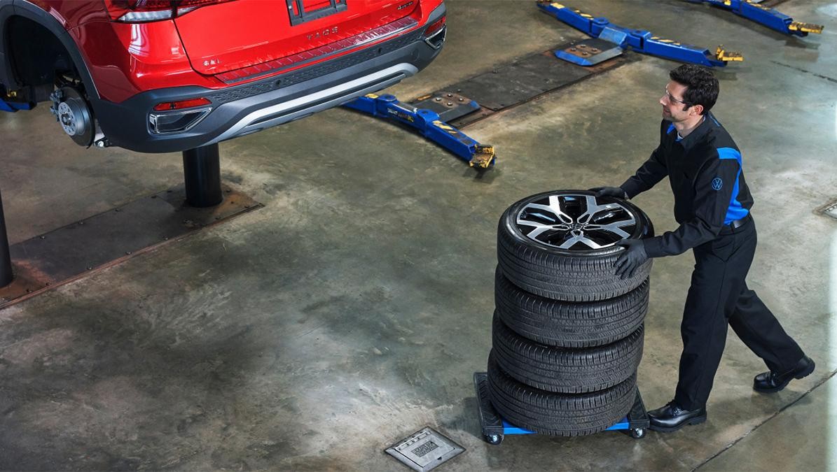 Volkswagen service technician mounting tire to vehicle