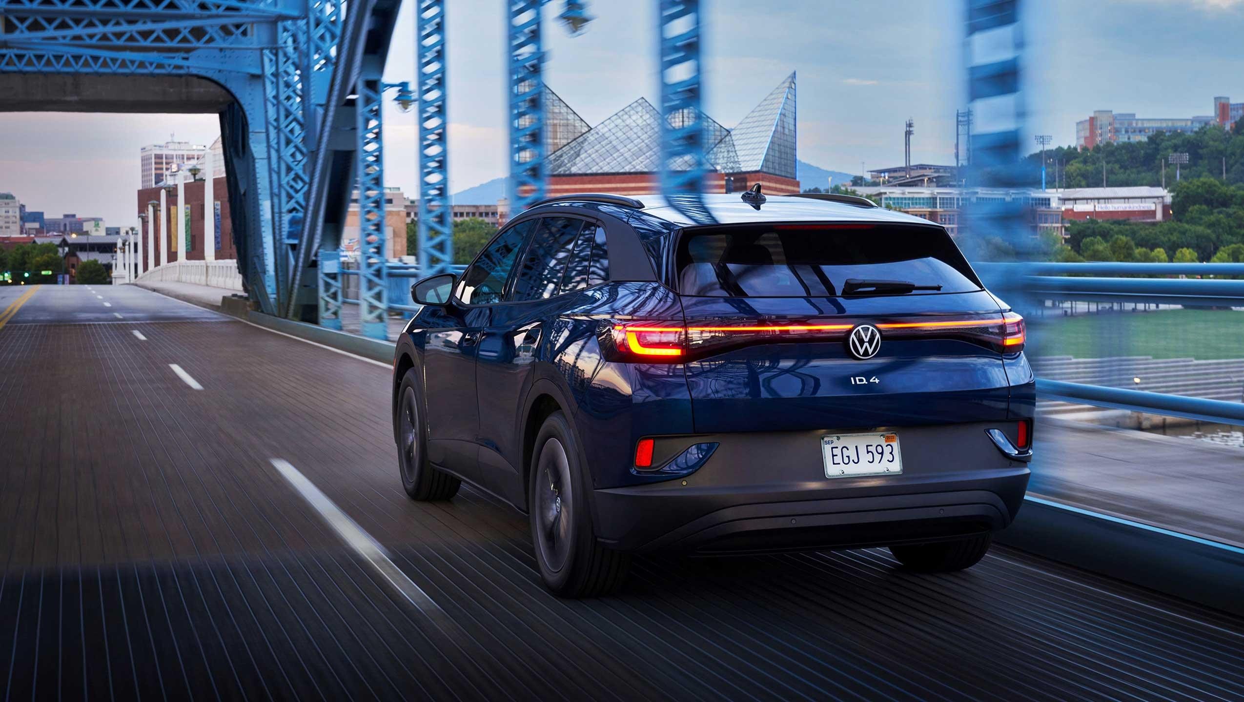 An ID.4 in Tourmaline Blue Metallic drives along a city street.