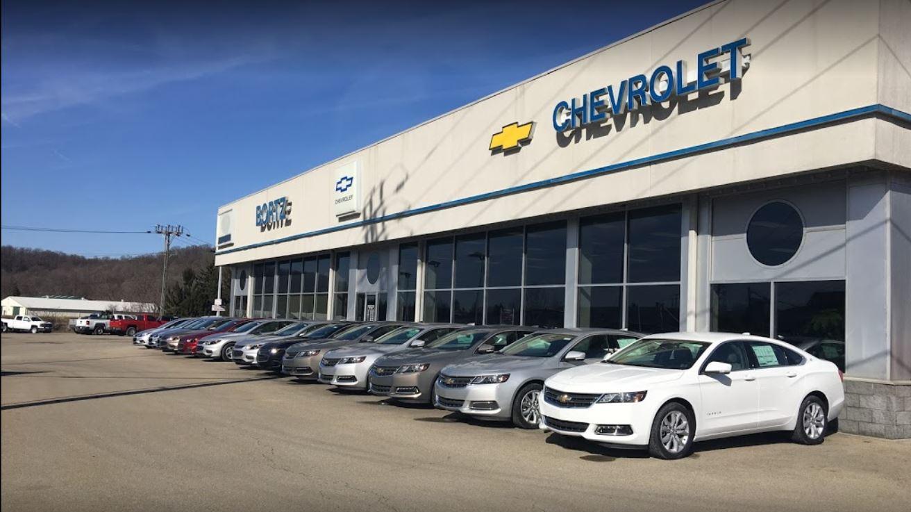 Woman Chatting with Salesperson in Dealership Showroom