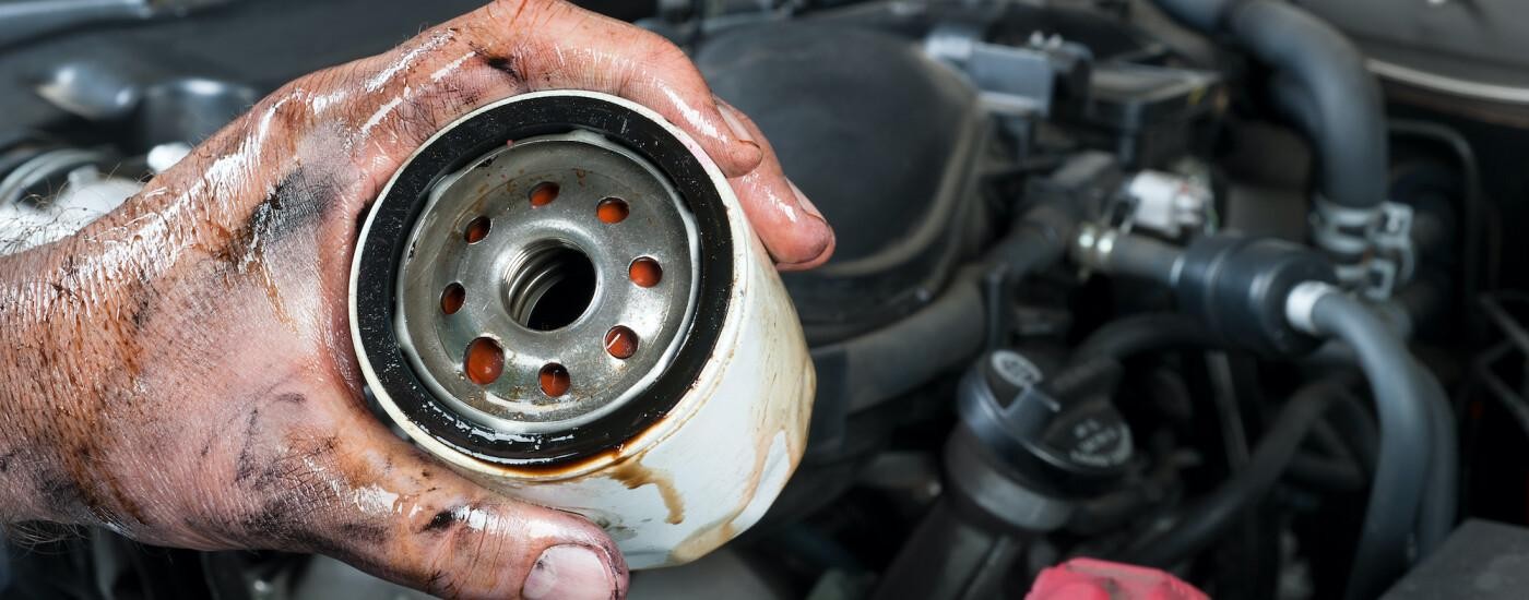 Mechanic holding dirty oil filter
