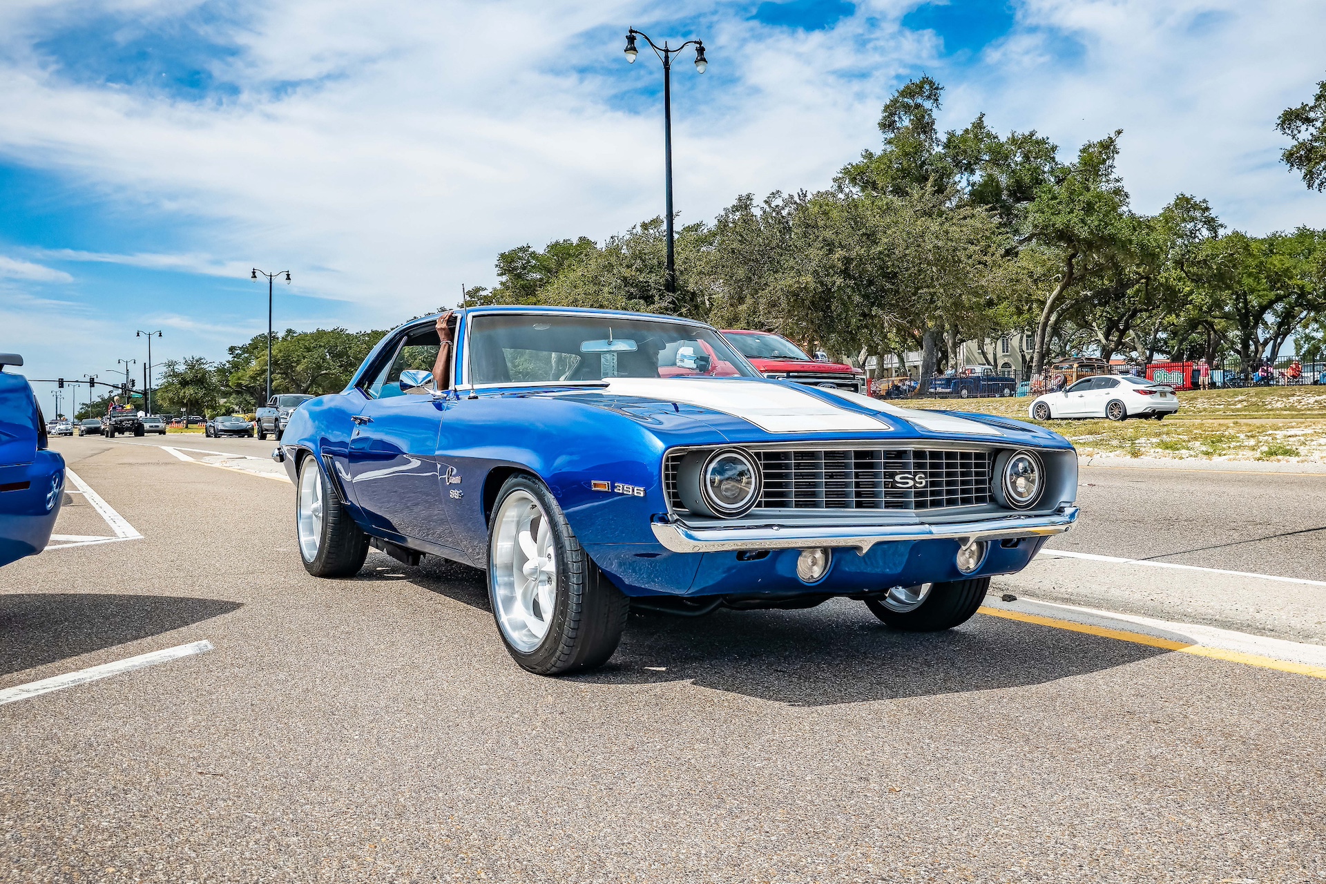 Blue Chevy Camaro parked by a forested roadside
