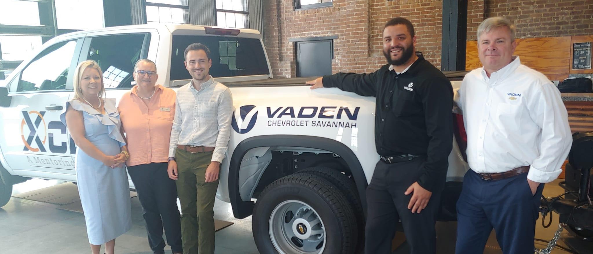 Vaden Chevrolet Savannah team poses in front of Chevrolet truck with Vaden Chevy logo on it.