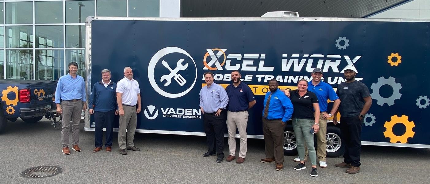 Regional Directors and General Manager, Neal Wilson, poses with Xcel Strategies Mobile Training Unit truck