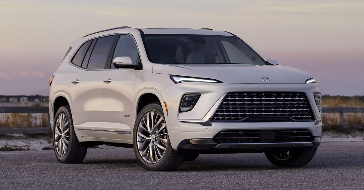 2025 Buick enclave exterior in white parked in front of a beach at sunset