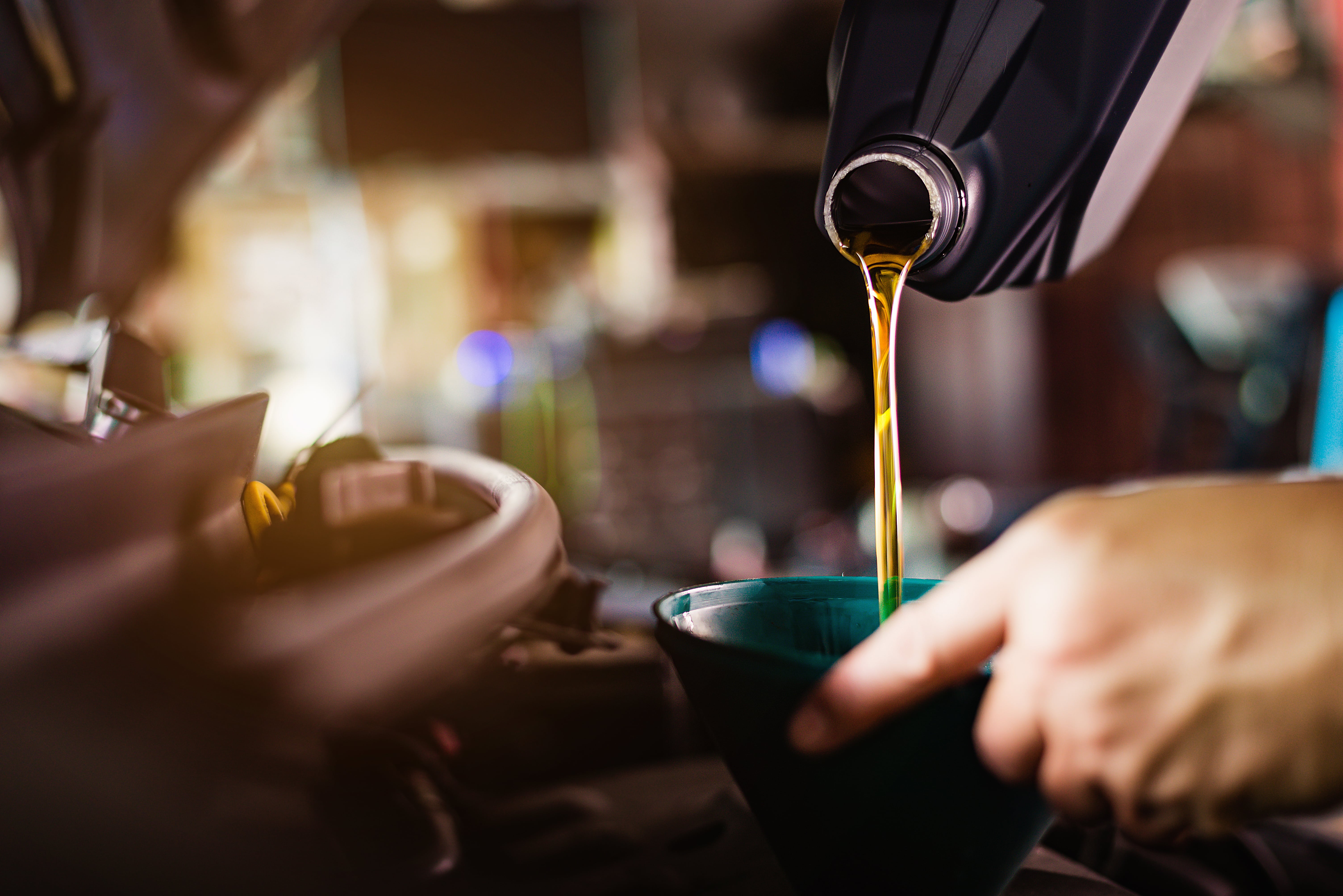 mechanic adding oil to a 2025 GMC Canyon