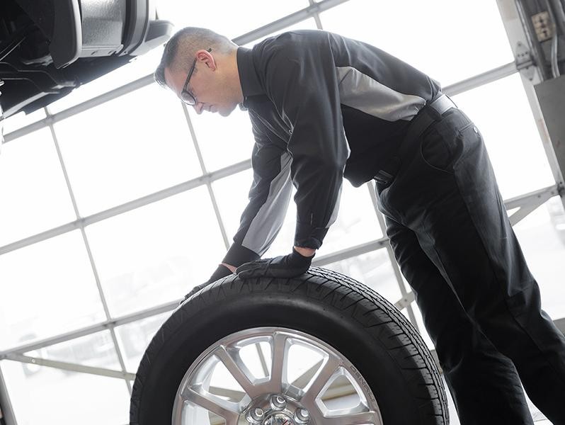 Photo of service technician replacing vehicle tire.