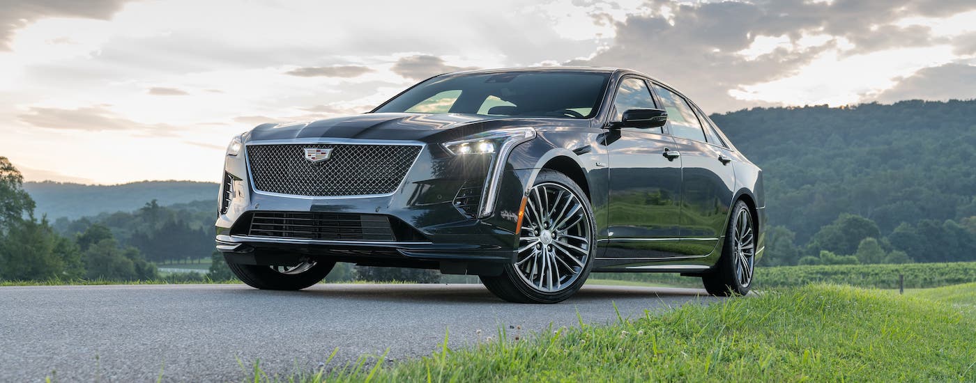 A dark gray 2019 Cadillac CT6-V used luxury car is parked in front of rolling hills at sunset. Visit your Fort Worth Cadillac dealer to see one today.