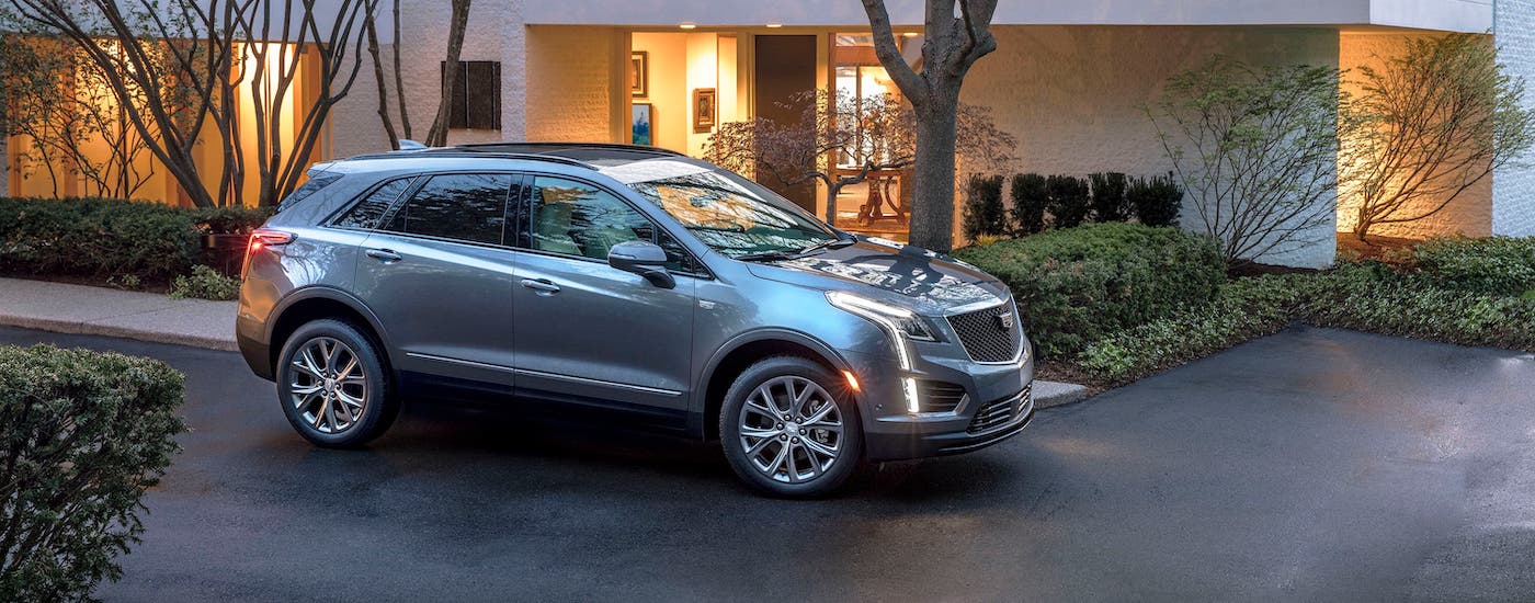 A popular Cadillac SUV model, a gray 2020 Cadillac XT5, is parked in front of a modern home near Fort Worth, TX.