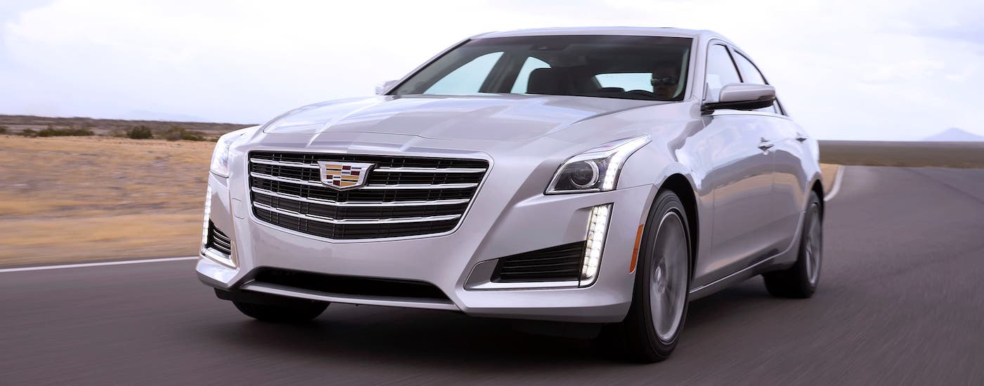 A white 2017 used Cadillac CTS sedan is driving on a highway near Fort Worth, TX.