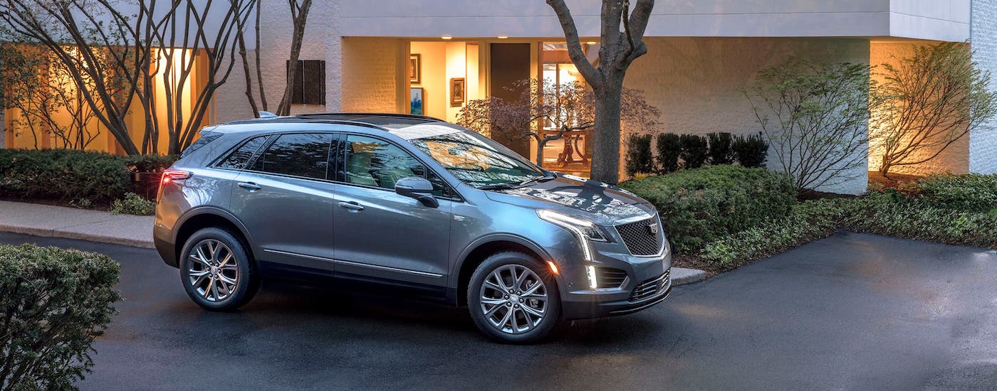 One of the popular Cadillac SUV models, a gray 2020 Cadillac XT5 Sport, is parked in front of a modern home in Fort Worth, TX.
