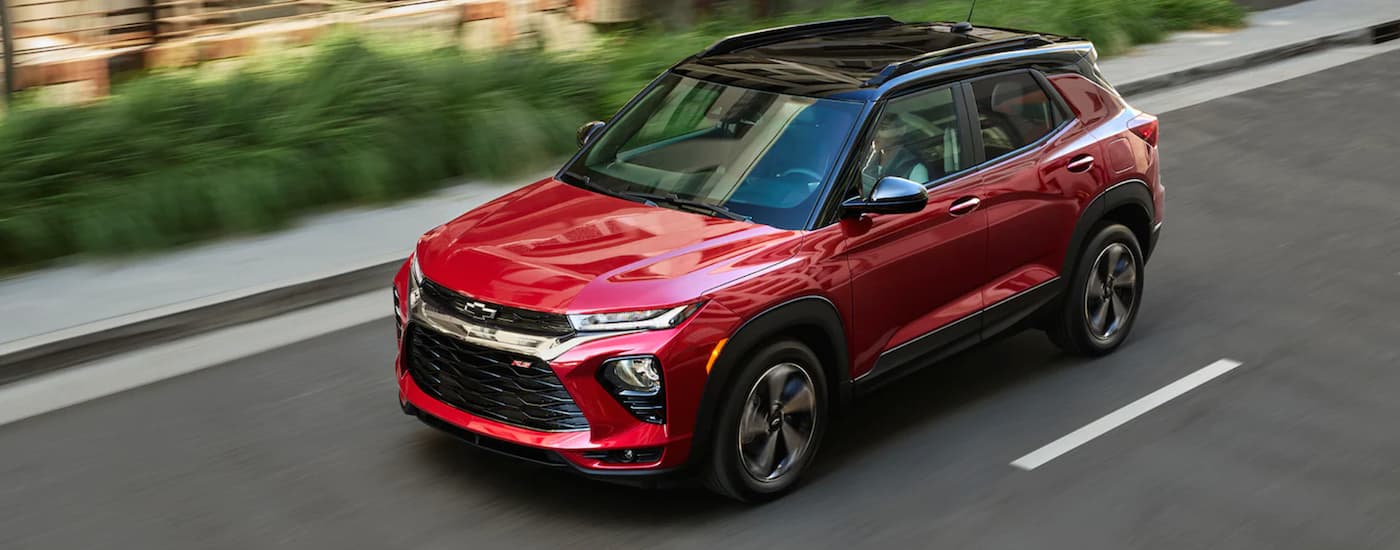 A red 2021 Chevy Trailblazer is driving past blurred shrubs after leaving a Tupelo GM dealer.