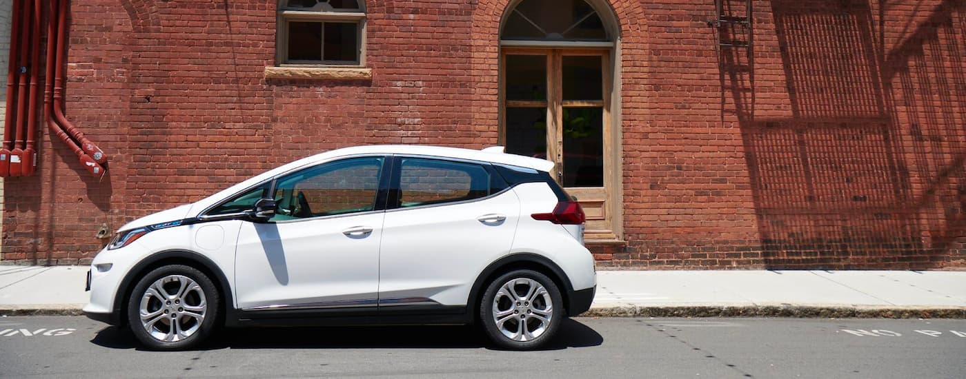 A white 2020 Chevy Bolt EV is shown outside a brick building after the owner found out how to sell your car.