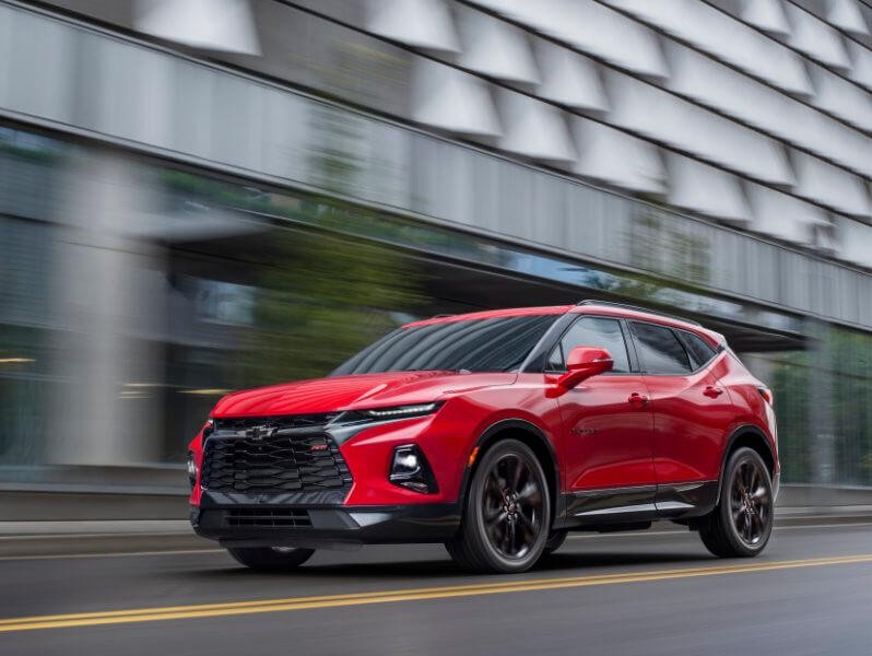 2019 Red Chevrolet Blazer Driving Past a Building