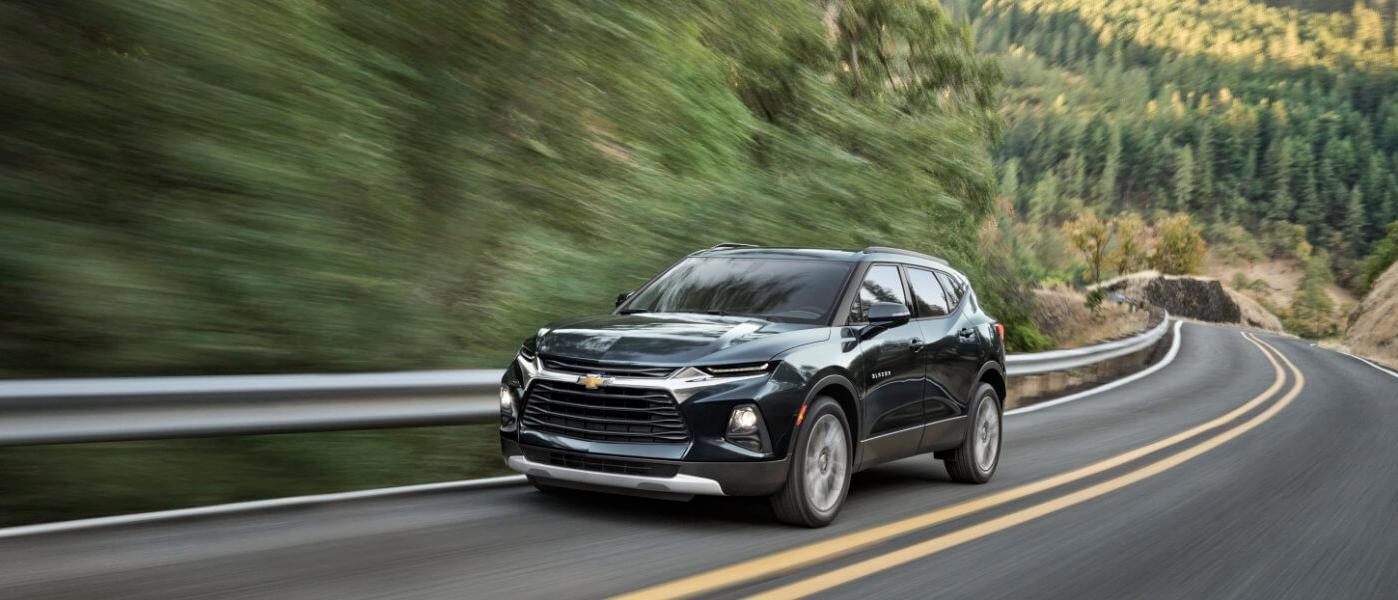 2019 Green Chevy Blazer Driving By Trees On A Highway