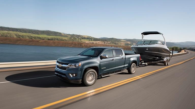 2019 Blue Chevy Colorado Towing a Boat Past Water