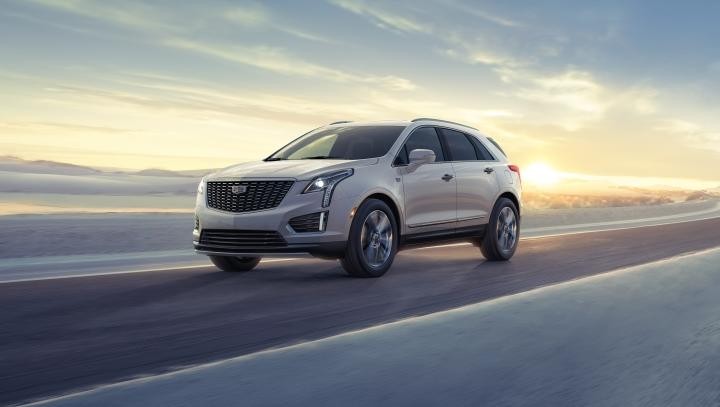 2025 Cadillac XT5 on road with sun setting in background