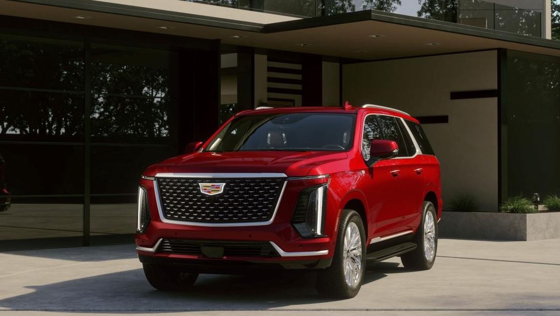 Red Cadillac 2025 Escalade parked in front of a modern house