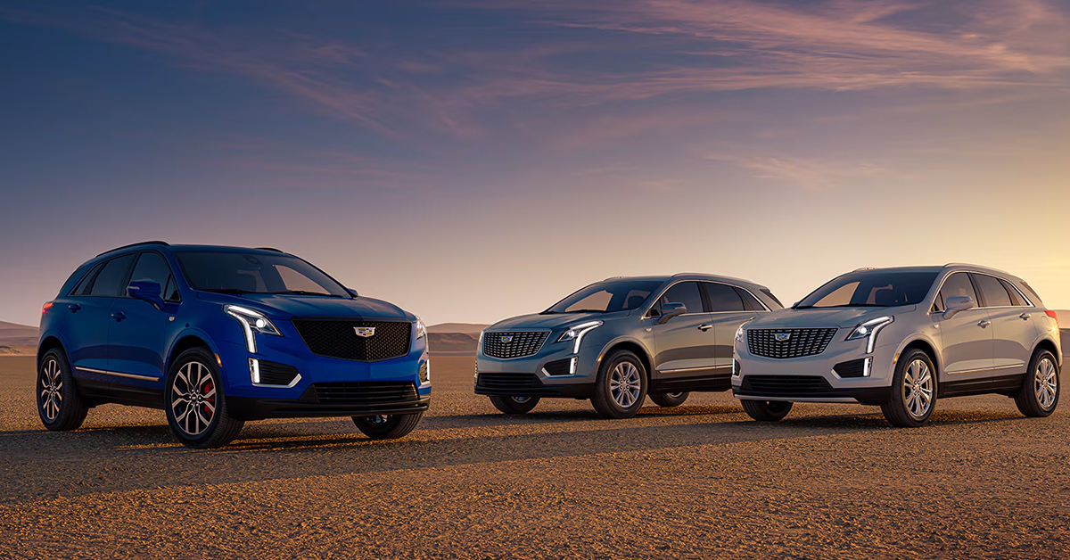 Cadillac SUVs parked in the desert at sunset
