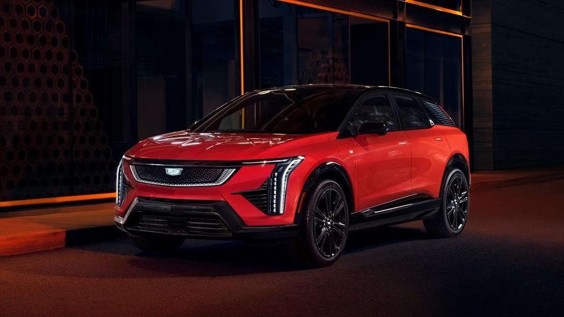 Red 2025 Cadillac Optiq parked in front of building