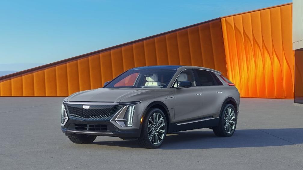 Silver 2025 Cadillac LYRIQ in front of gold wall